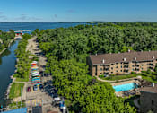 Thumbnail 23 of 25 - A view of a resort with a pool and a river.