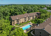Thumbnail 24 of 25 - A large building with a pool surrounded by trees.