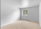 Thumbnail 9 of 25 - A room with a window and a carpeted floor.