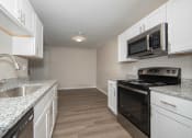 Thumbnail 12 of 16 - a kitchen with white cabinets and black appliances