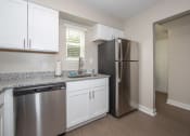Thumbnail 5 of 16 - newly renovated kitchen with white cabinets, stainless steel appliances, and granite countertops