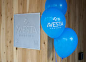 Thumbnail 16 of 21 - A wooden wall with a sign that says Avesta Housing and blue balloons.