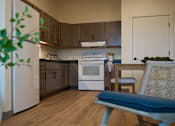 Thumbnail 5 of 21 - A kitchen with a white refrigerator, a white oven, and brown cabinets.