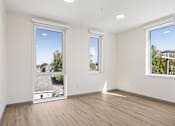 Thumbnail 9 of 21 - A room with two windows and wooden flooring.