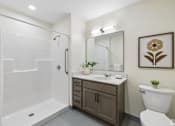 Thumbnail 13 of 21 - A bathroom with a white toilet, a white sink, a white bathtub, and a brown cabinet.