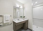 Thumbnail 14 of 21 - A bathroom with a sink, mirror, and bathtub.