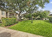 Thumbnail 1 of 38 - Courtyard with mature trees and lawn at Parks on the Green Apartments, Temple