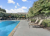 Thumbnail 2 of 38 - Resort style swimming pool with lounge chairs at Parks on the Green Apartments, Texas