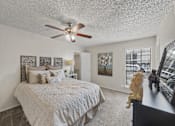 Thumbnail 8 of 38 - Master bedroom with ceiling fan and decor at Parks on the Green Apartments, Temple, Texas