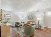 Thumbnail 29 of 38 - Furnished living room with sage armchairs at Parks on the Green Apartments, Temple