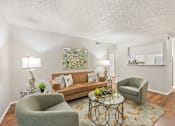 Thumbnail 35 of 38 - Living room with brown sofa and chairs at Parks on the Green Apartments, Texas, 76504