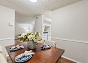 Thumbnail 37 of 38 - Dining room with wood table and place settings at Parks on the Green Apartments, Temple, TX 76504