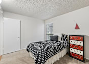 Thumbnail 28 of 38 - Bedroom with black polka dot bedding and colorful dresser at Parks on the Green Apartments, Temple, 76504