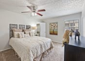 Thumbnail 21 of 38 - Master bedroom with textured bedding and window at Parks on the Green Apartments, Temple, Texas