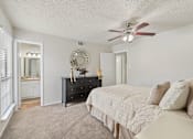 Thumbnail 34 of 38 - Master bedroom with ensuite bathroom and black dresser at Parks on the Green Apartments, Temple