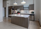 Thumbnail 17 of 18 - A modern kitchen with a large island in the center.