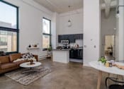 Thumbnail 7 of 14 - a living room with a couch and a kitchen