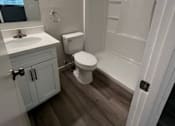 Thumbnail 2 of 8 - A white bathroom with a toilet, sink, and mirror.