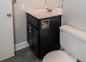 Thumbnail 16 of 25 - Bathroom with a toilet sink and mirror at McDonogh Village Apartments & Townhomes, Randallstown