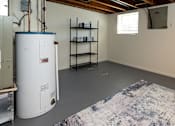 Thumbnail 18 of 36 - Basement with water heater and a window.