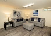 Thumbnail 15 of 36 - Basement with hardwood, vinyl flooring with couches and ottoman