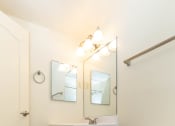 Thumbnail 20 of 33 - a bathroom with a toilet sink and mirror at Seminary Roundtop Apartments, Lutherville, Maryland