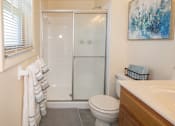 Thumbnail 30 of 36 - Bathroom with toilet, sink with cabinets and stand-alone shower A bathroom with a toilet, sink, and shower.