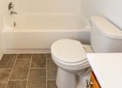 Thumbnail 10 of 20 - A white toilet sits next to a bathtub in a bathroom.at Severn Townhomes*, Severn, MD 21144