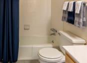 Thumbnail 19 of 32 - Bathroom with a white toilet next to a white bathtub at Seven Oaks Townhomes, Edgewood, MD