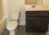 Thumbnail 12 of 16 - A white toilet sits next to a sink in a bathroom at Lawyers Hill Apartments, Elkridge, 21075