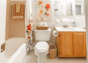 Thumbnail 10 of 15 - a white bathroom with orange flowers on the shower curtain at Lawyers Hill Apartments, Elkridge, 21075