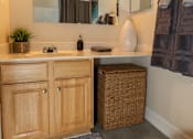 Thumbnail 11 of 27 - A bathroom with a vanity, mirror, and lights.at Deer Park Apartments, Randallstown, MD 21133