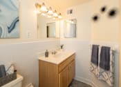 Thumbnail 14 of 26 - A bathroom with a white sink and a mirror above it.
