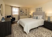 Thumbnail 5 of 10 - A bedroom with a large bed, a nightstand, and a chair at Hyde Park Apartments*, Essex, MD 21221
