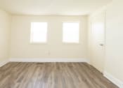 Thumbnail 17 of 23 - Empty room with a wooden floor and two windows at The Orchards at Severn Townhomes*, Severn Maryland