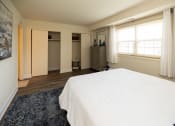 Thumbnail 13 of 23 - Bedroom with a white bed and a blue rug at Rockdale Gardens Apartments*, Baltimore, MD