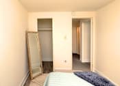 Thumbnail 12 of 15 - A bedroom with a bed, mirror and wardrobe at Kingston Townhomes, Baltimore, MD