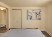Thumbnail 20 of 26 - A bedroom with a bed, a painting on the wall, and a sliding door.