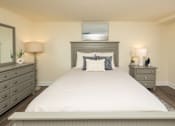 Thumbnail 6 of 20 - A bedroom with a large bed, two nightstands, and a mirror. at Colony Hill Apartments & Townhomes, Baltimore, MD
