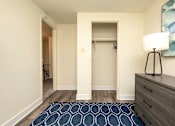 Thumbnail 10 of 15 - A hallway with a rug and a lamp on the side table at Kingston Townhomes, Baltimore, MD