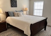 Thumbnail 6 of 9 - A bedroom with a large bed and a patterned rug.