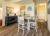 Thumbnail 7 of 32 - Dining area with a table and chairs and a kitchen in the background at Seven Oaks Townhomes, Edgewood, MD
