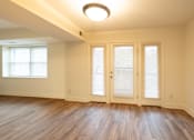 Thumbnail 5 of 25 - an empty living room with wood floors and french doors  at Charlesgate Apartments, Towson, MD, 21204