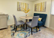 Thumbnail 16 of 16 - A dining room with a round table and grey chairs  at Winston Apartments, Baltimore, Maryland