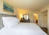 Thumbnail 13 of 29 - Guest bedroom with bed and dresser and double door closet at Woodridge Apartments.
