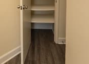 Thumbnail 11 of 16 - A white door with a handle is open to a hallway with shelves at Lawyers Hill Apartments, Elkridge, 21075