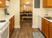Thumbnail 5 of 29 - a kitchen with white appliances and wooden cabinets and a rug