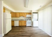 Thumbnail 6 of 23 - Kitchen with white appliances and wooden cabinets at The Orchards at Severn Townhomes*, Severn, MD