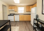 Thumbnail 5 of 26 - A kitchen with wooden cabinets and a black counter top.