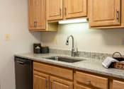 Thumbnail 3 of 28 - A kitchen with wooden cabinets and a granite countertop.